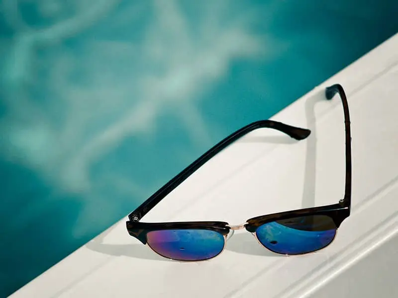 A pair of sunglasses by the pool