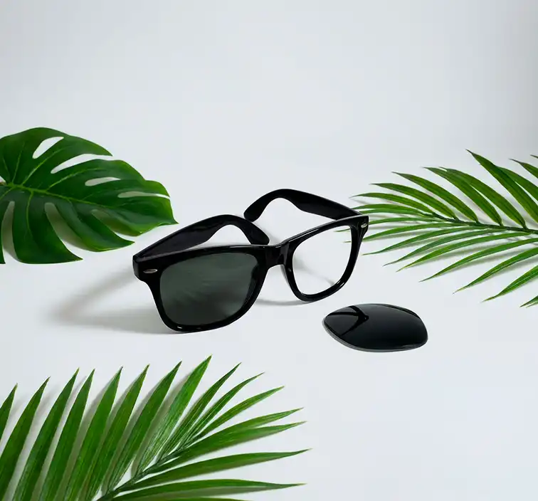 Highest-quality optical polyamide lenses with glass-like clarity Black Wayfarer sunglasses showing the removal of an old lens for a premium replacement